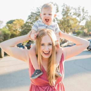 Lydia Storie, Senior Culture Change Manager with her son on her shoulders