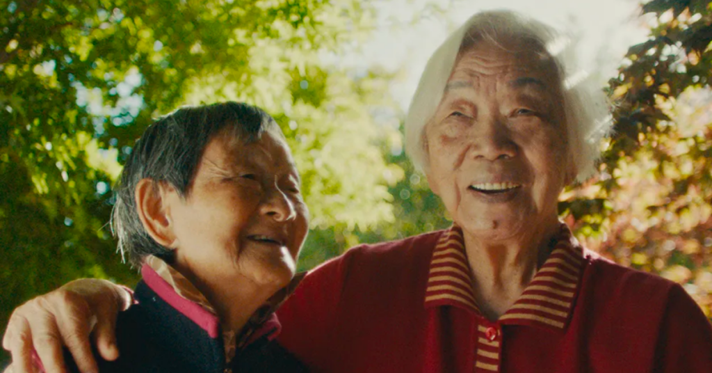 An image from the documentary 'Nai Nai and Waipo' featuring two grandmothers embracing each other.