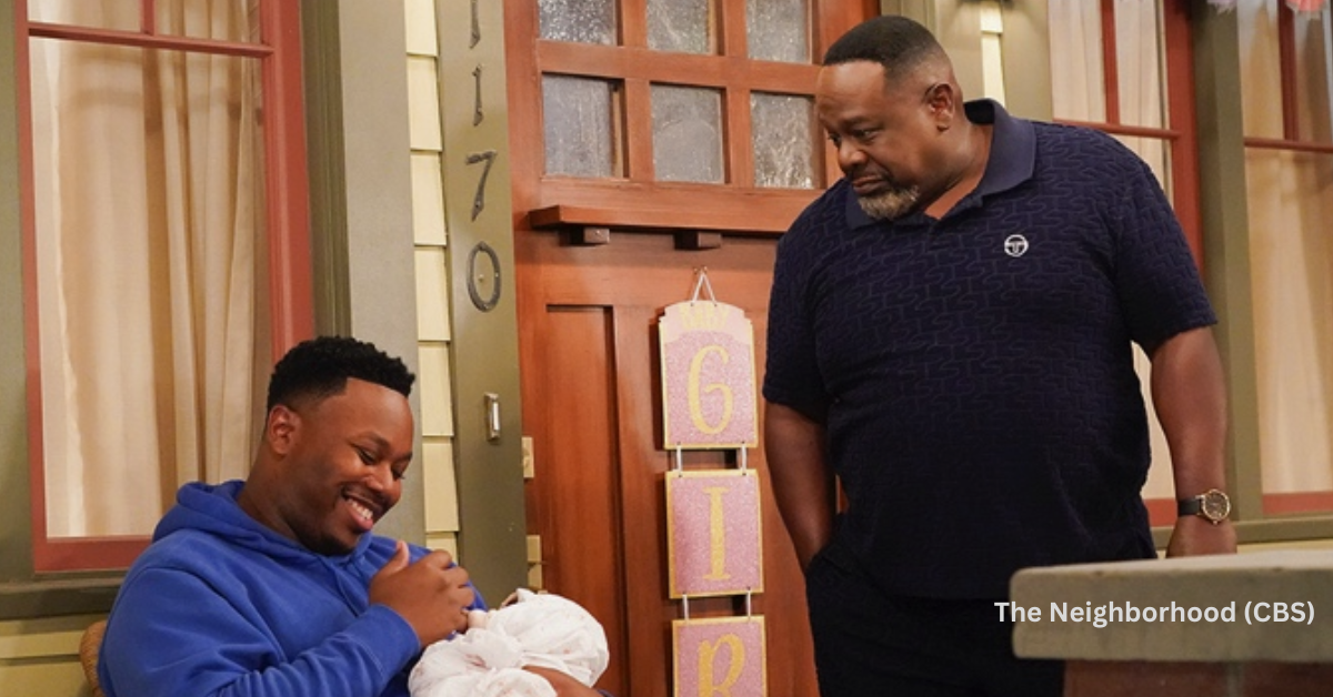 A son holding his newborn baby while talking to his father on the porch.