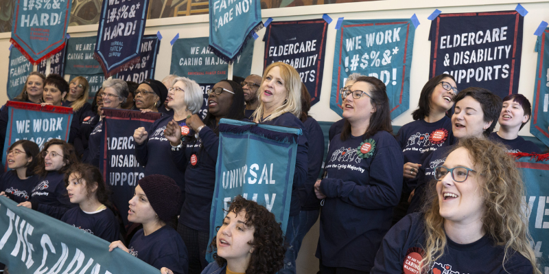 Care advocates holding signs for better care policies.