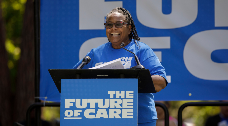 A woman at a podium speaking to a crowd.