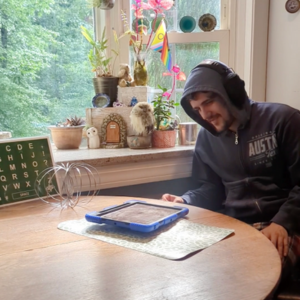 A photo of disabled man communicating using assistive technology.