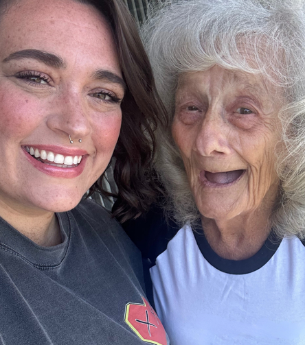 A woman and her grandmother pose for a selfie.