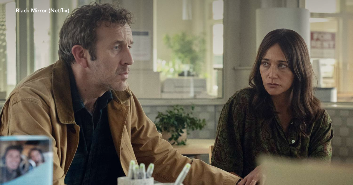 A woman holding her husband's hand while sitting in an office space, looking concerned.