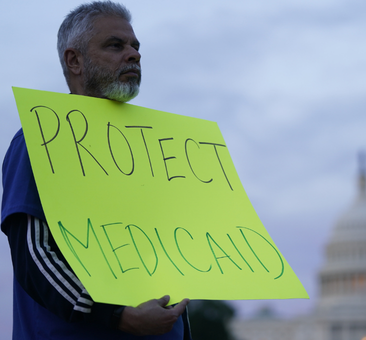 A man holds a bright yellow sign reading 